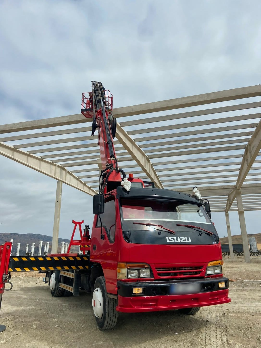 27 metre kırmızı sepetli platform şantiye sahasında